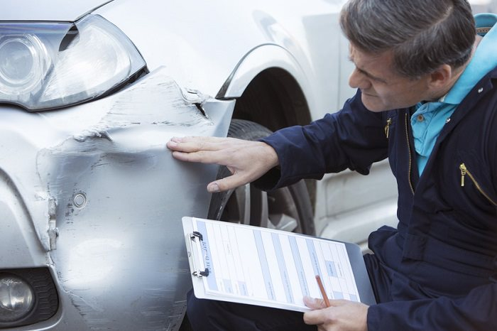 Person inspecting a damaged vehicle